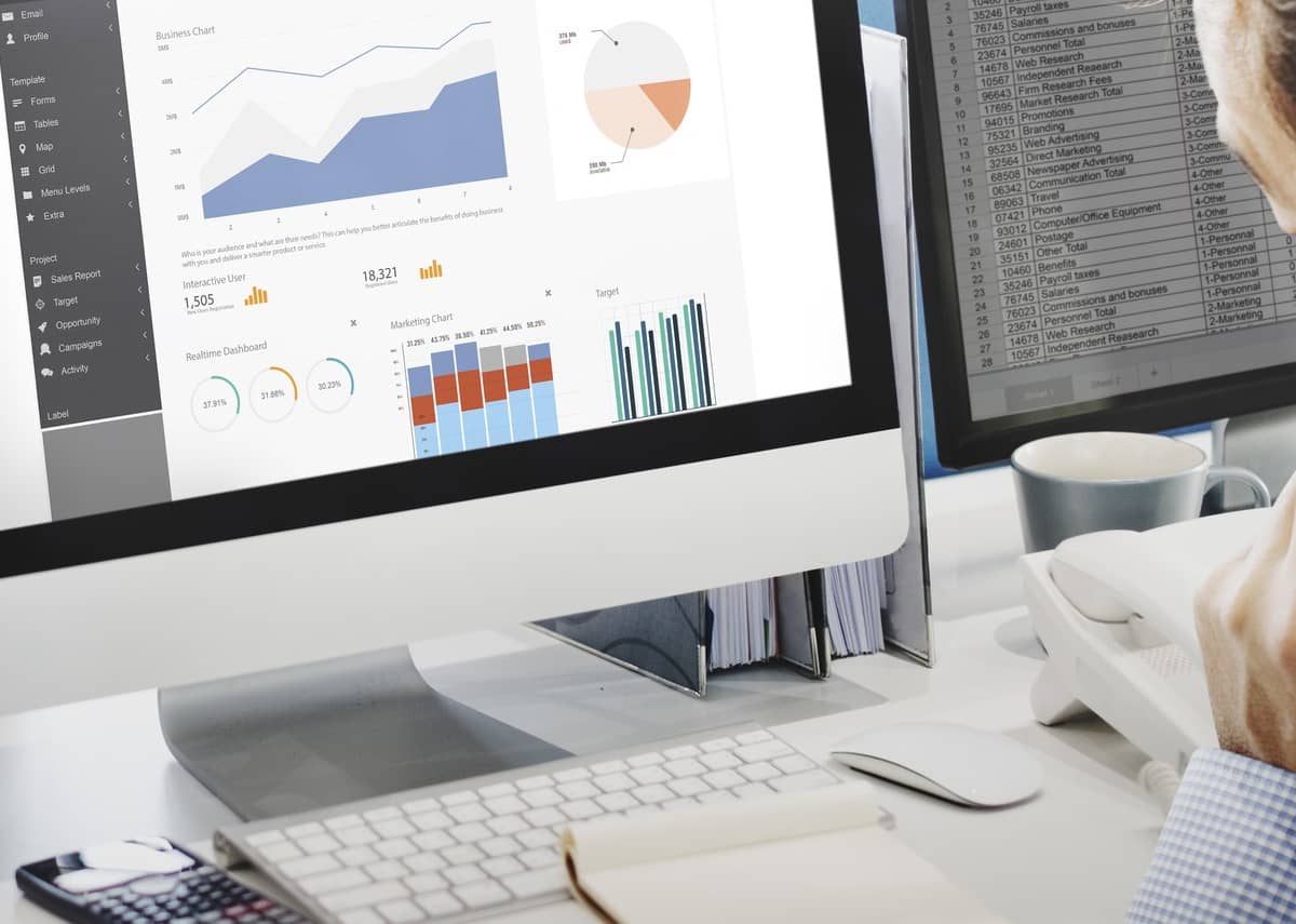 Telefonierender Mitarbeiter vor Monitor mit Charts